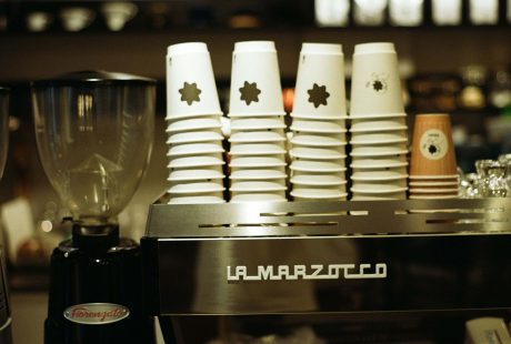 Alcuni bicchieri di plastica bianca e una macchina per il caffè